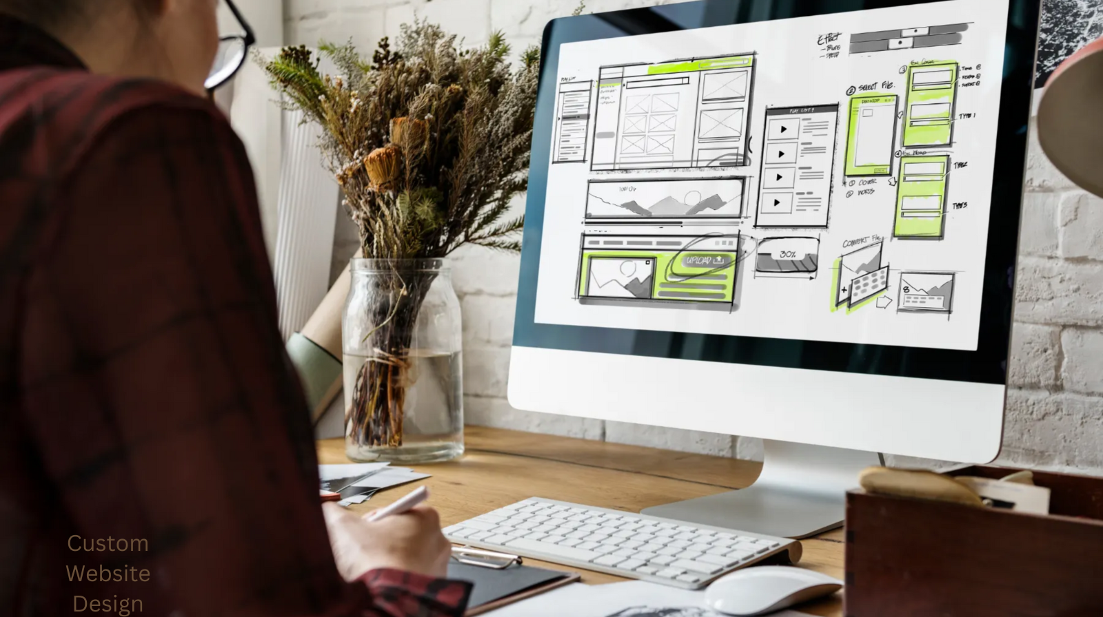 Designer creating a custom website layout on a computer.