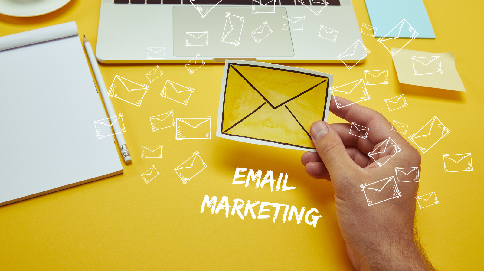 cropped image of man holding envelope near laptop with "Email Marketing" lettering and email icon Email Marketing for E-Commerce